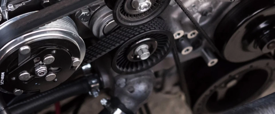 Close-up of a marine engine with belts and pulleys.