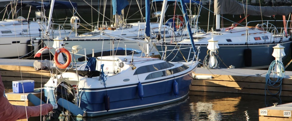 Boats moored in a marina, illustrating the ongoing costs of owning and maintaining a boat.