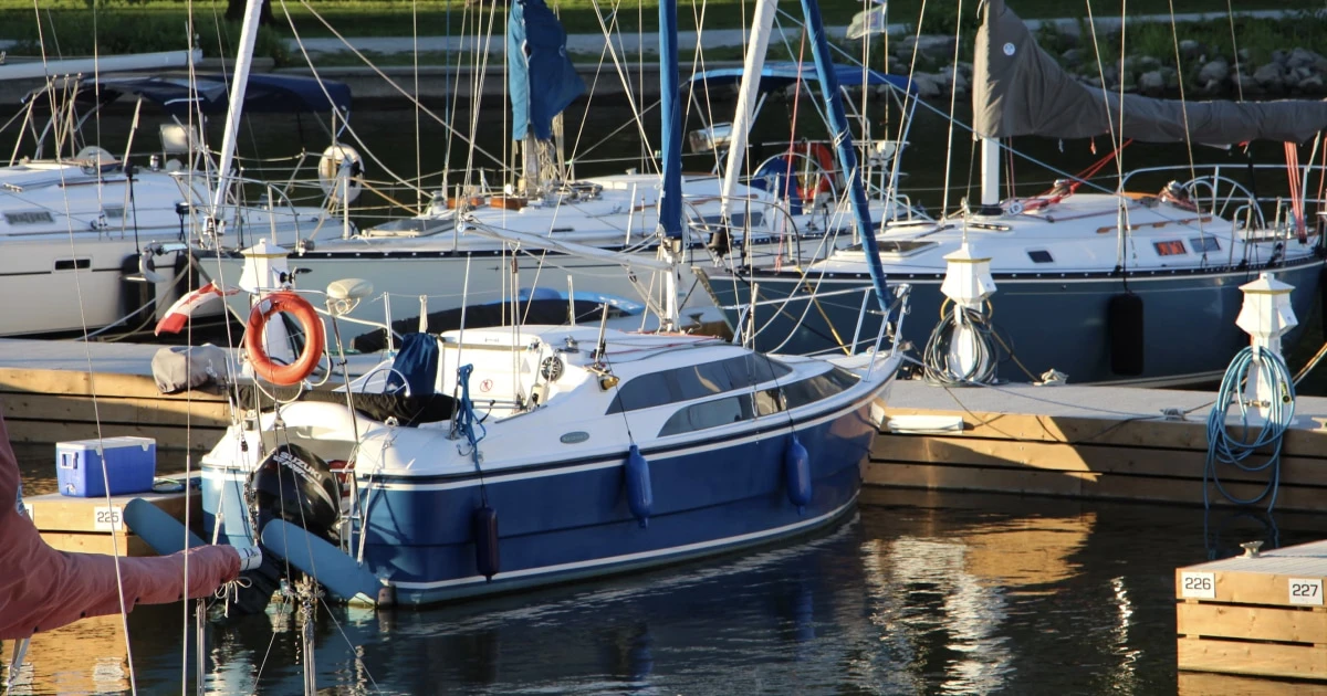 Boats moored in a marina, illustrating the ongoing costs of owning and maintaining a boat.