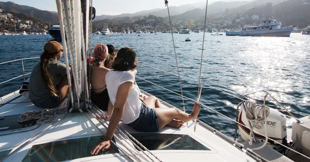 Sailors sitting together aboard a boat and documenting their time on the water.