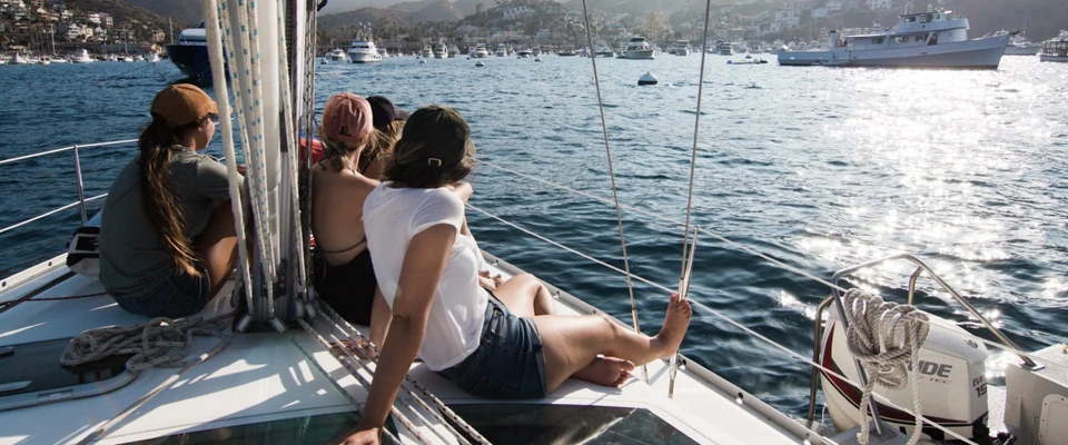 Sailors sitting together aboard a boat and documenting their time on the water.