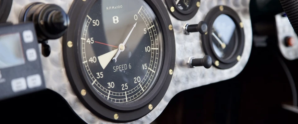 Close-up of a marine engine instrument panel with an analog gauge and hour meter.