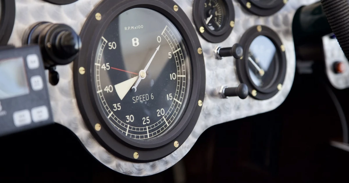 Close-up of a marine engine instrument panel with an analog gauge and hour meter.