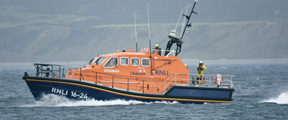 Orange rescue boat operating at sea, illustrating a maritime man-overboard response.