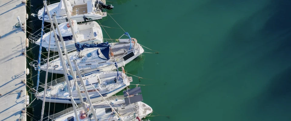 Sailboats moored in a marina viewed from above, illustrating preparations before departure.