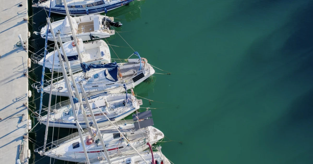 Sailboats moored in a marina viewed from above, illustrating preparations before departure.