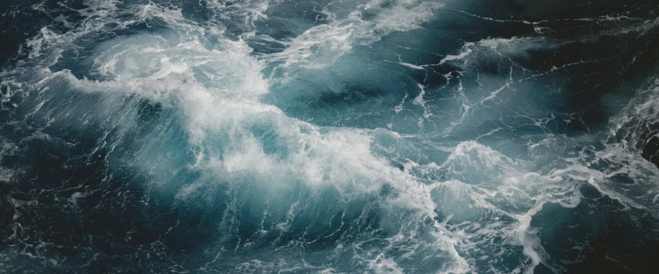 Large waves breaking into white foam on the open sea.