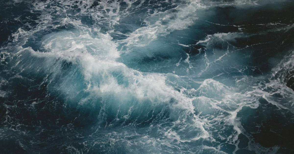 Large waves breaking into white foam on the open sea.