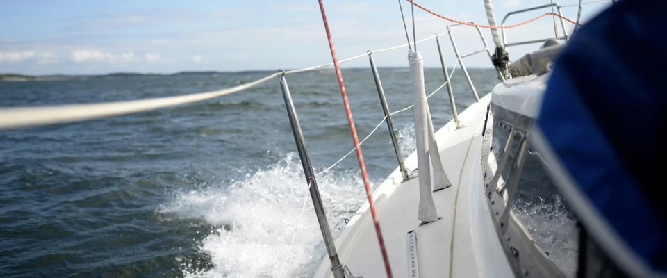 Sailboat bow throwing spray as it sails fast through the waves.