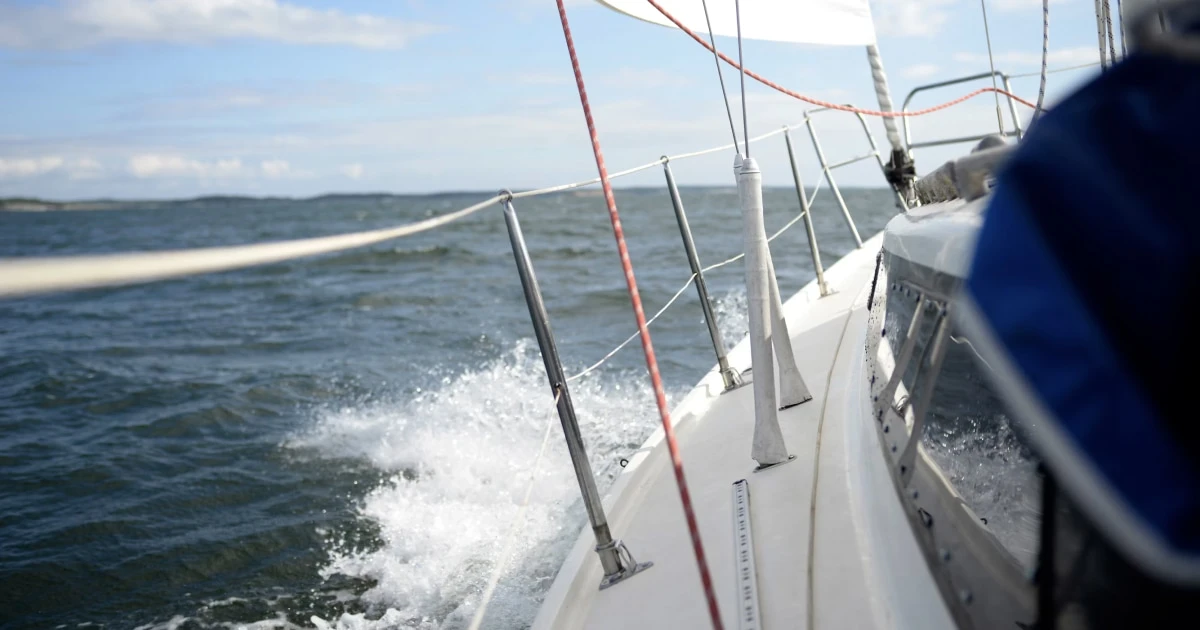 Sailboat bow throwing spray as it sails fast through the waves.