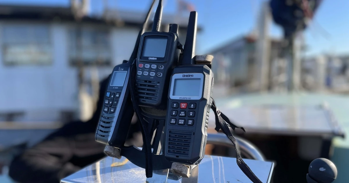 Handheld VHF marine radios in their holders on a boat.