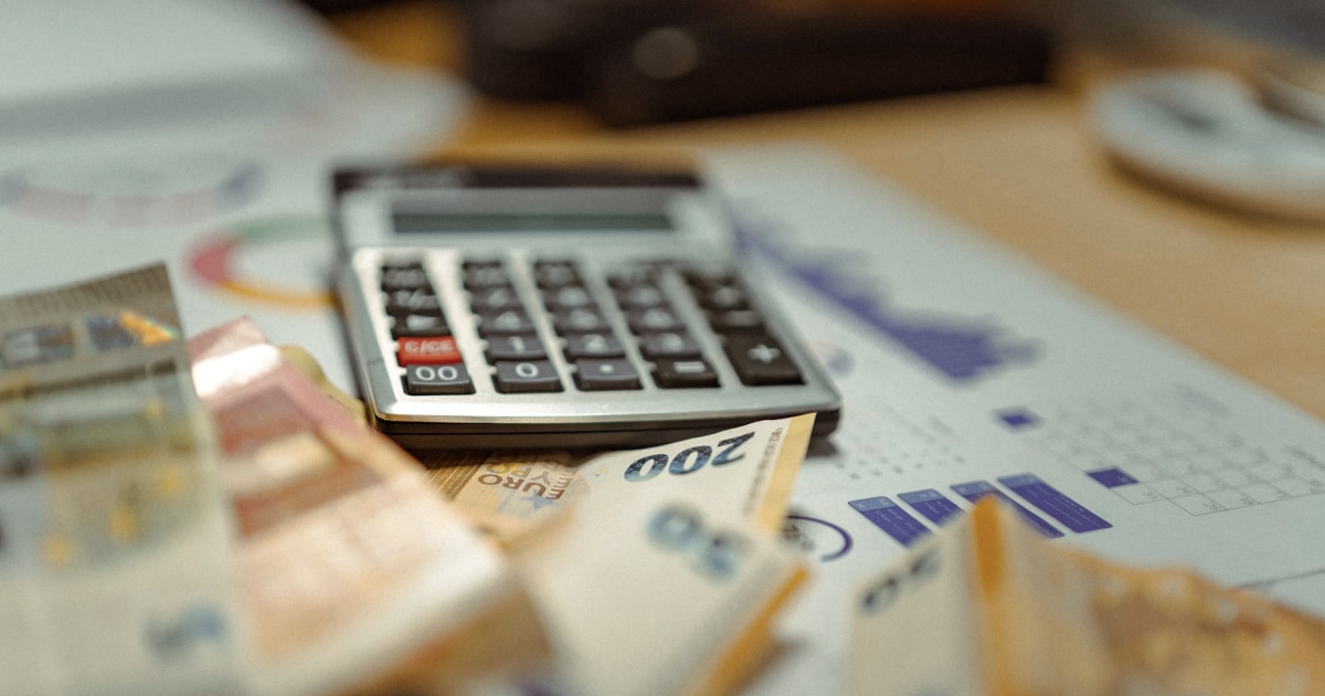 Calculator and financial documents on a desk, used to review and calculate boat ownership expenses.