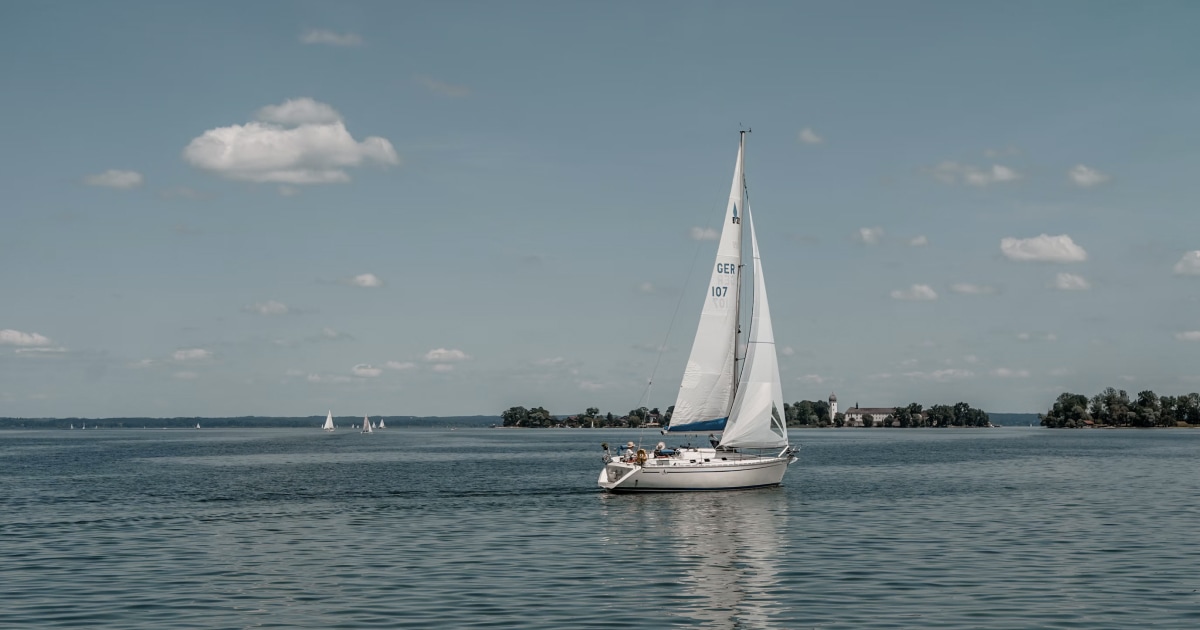 Sailboat underway on open water beneath a partly cloudy sky, illustrating sailing in changing wind conditions.